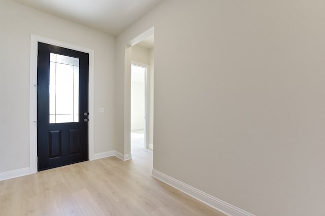 entryway with baseboards and light wood finished floors