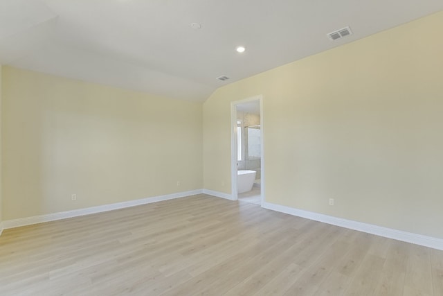 unfurnished room featuring vaulted ceiling, baseboards, visible vents, and light wood finished floors