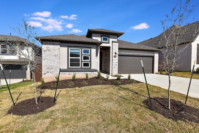 prairie-style home featuring concrete driveway, brick siding, a garage, and a front yard