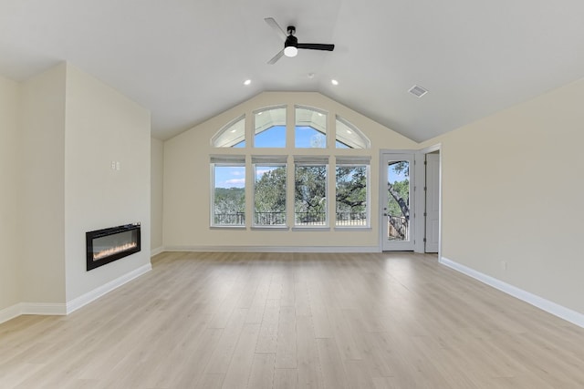 unfurnished living room with visible vents, light wood-style flooring, a ceiling fan, a glass covered fireplace, and lofted ceiling