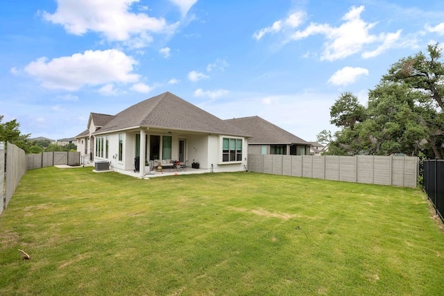 back of house featuring a lawn, central AC unit, and a patio