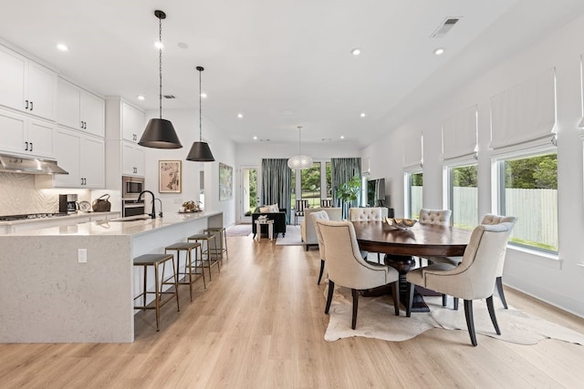 dining room with sink and light wood-type flooring