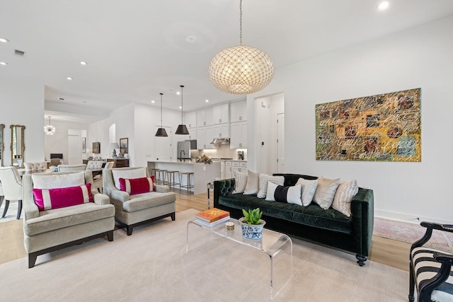 living room featuring an inviting chandelier and light hardwood / wood-style flooring