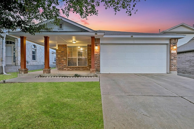 single story home featuring a garage and a lawn