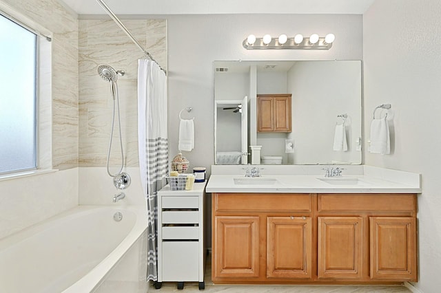 full bathroom featuring toilet, vanity, ceiling fan, and shower / tub combo with curtain