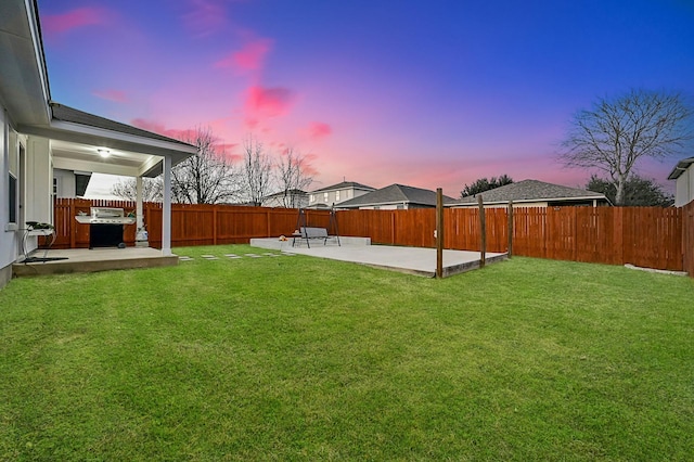 yard at dusk featuring a patio