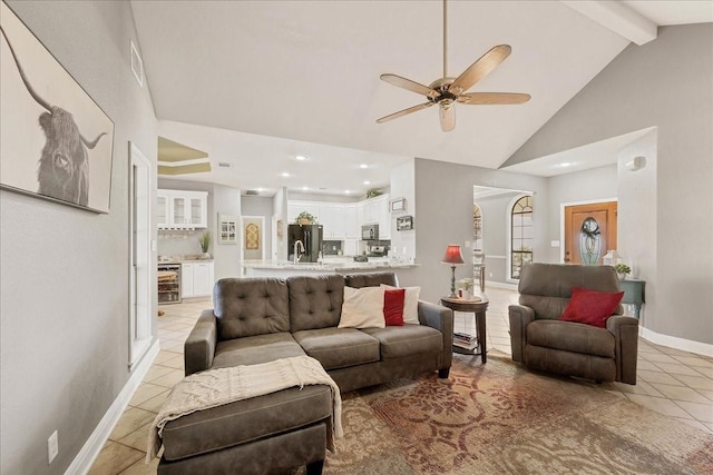 living room with beverage cooler, beamed ceiling, high vaulted ceiling, ceiling fan, and light tile patterned floors