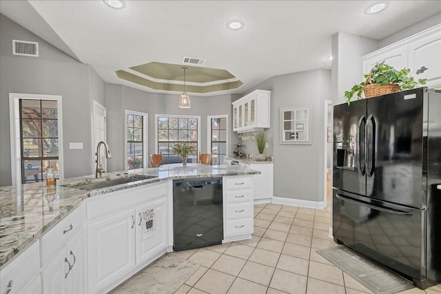 kitchen featuring white cabinetry, sink, a tray ceiling, and black appliances