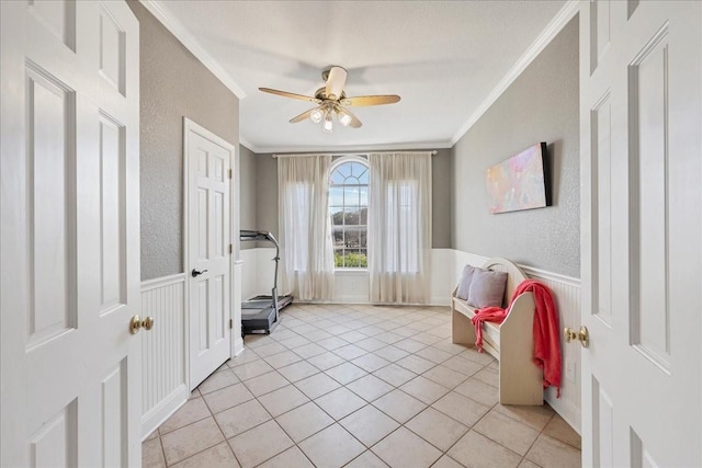 interior space featuring ceiling fan, light tile patterned floors, and ornamental molding