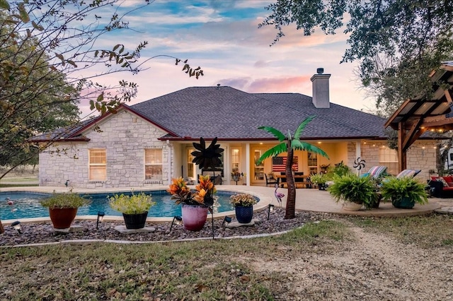 back house at dusk with a patio area