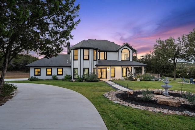 view of front of home with covered porch and a yard