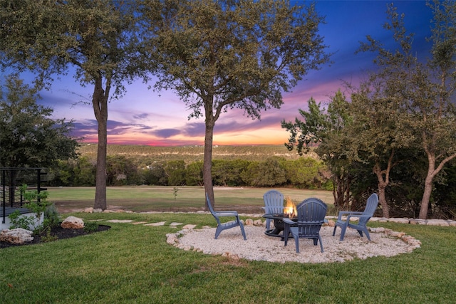 yard at dusk featuring a fire pit