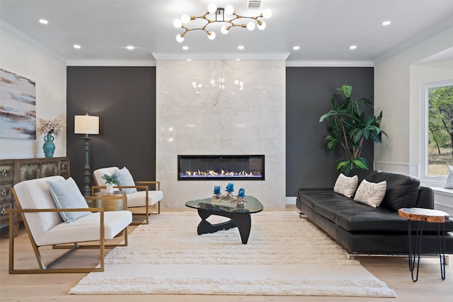 living room with light hardwood / wood-style flooring, crown molding, and a tiled fireplace