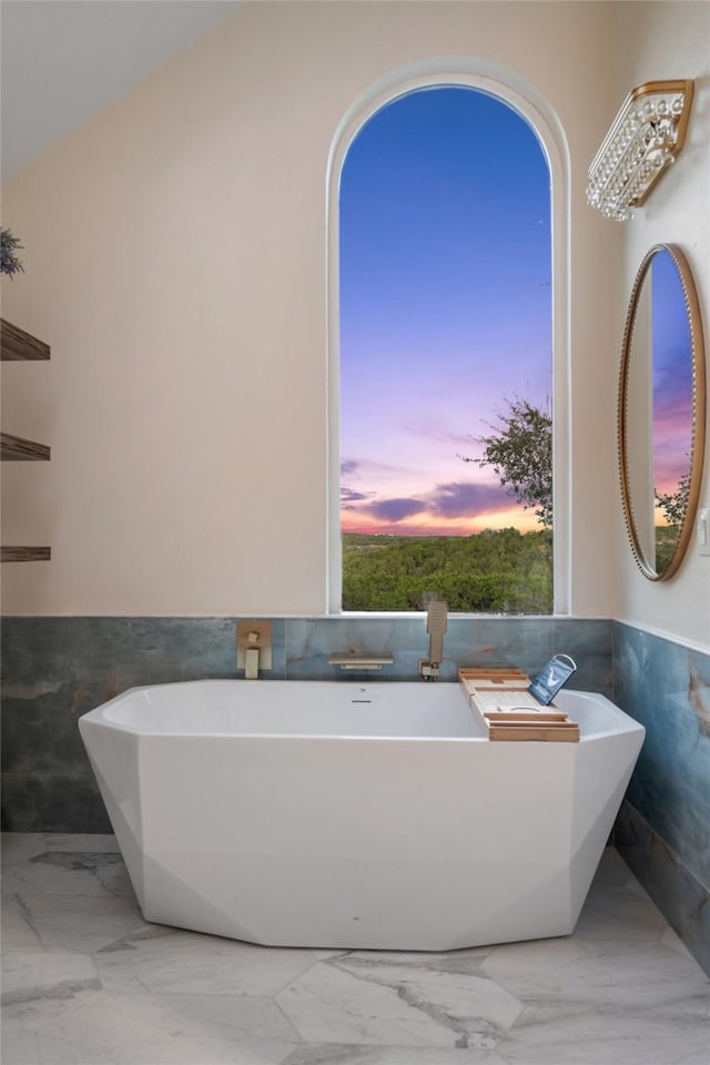 bathroom featuring tile walls and a washtub