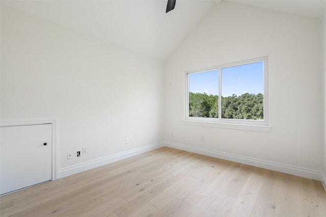 empty room featuring high vaulted ceiling and light hardwood / wood-style flooring