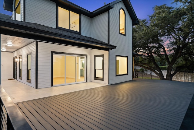 back house at dusk featuring a patio area