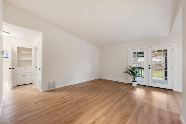 spare room featuring light hardwood / wood-style flooring and french doors