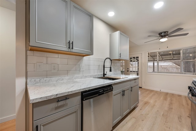 kitchen with stainless steel appliances, gray cabinetry, decorative backsplash, light wood-type flooring, and sink