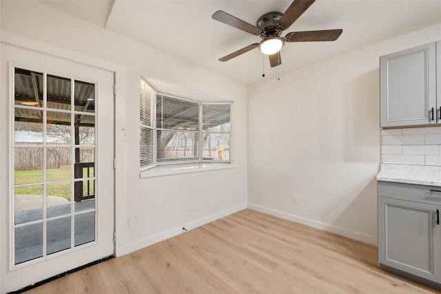 unfurnished dining area featuring ceiling fan and light wood-type flooring