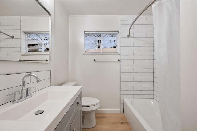 full bathroom featuring wood-type flooring, toilet, vanity, and shower / bath combo