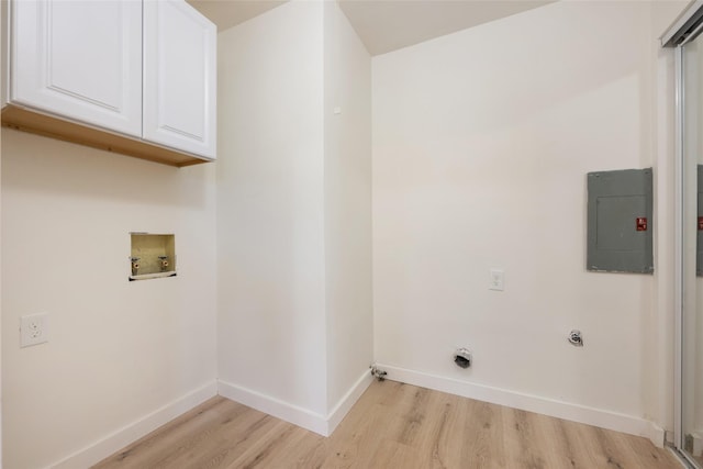 clothes washing area with light hardwood / wood-style floors, electric panel, hookup for a washing machine, electric dryer hookup, and cabinets