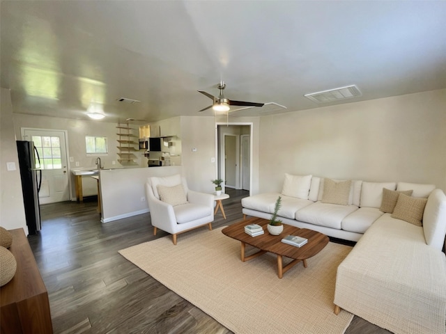 living room with ceiling fan and dark hardwood / wood-style flooring