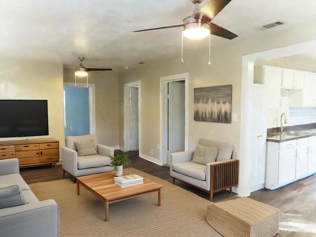 living room featuring ceiling fan, sink, and hardwood / wood-style flooring