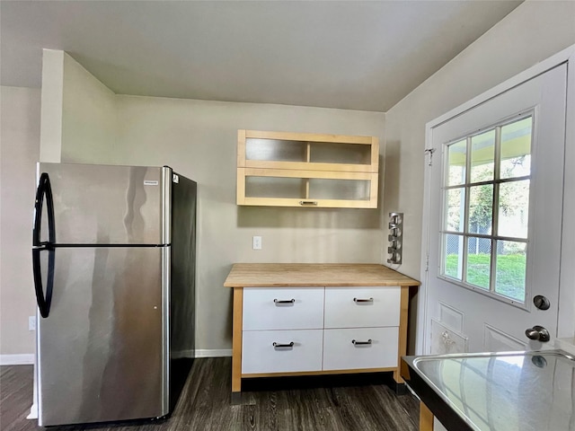 kitchen with white cabinetry, dark hardwood / wood-style floors, wooden counters, and stainless steel refrigerator