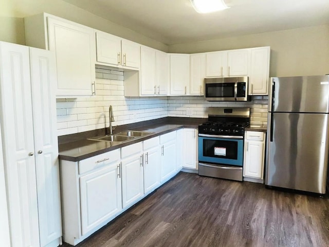 kitchen with white cabinets, stainless steel appliances, decorative backsplash, sink, and dark hardwood / wood-style floors