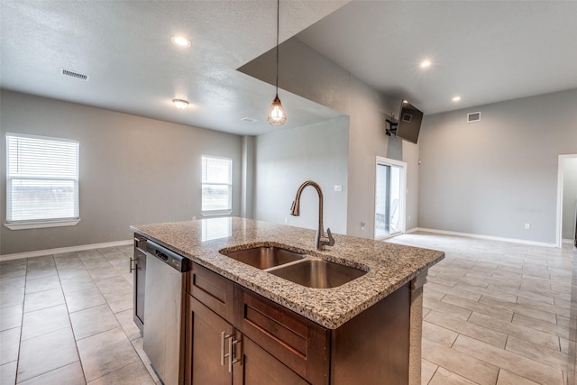 kitchen featuring decorative light fixtures, sink, plenty of natural light, a kitchen island with sink, and stainless steel dishwasher