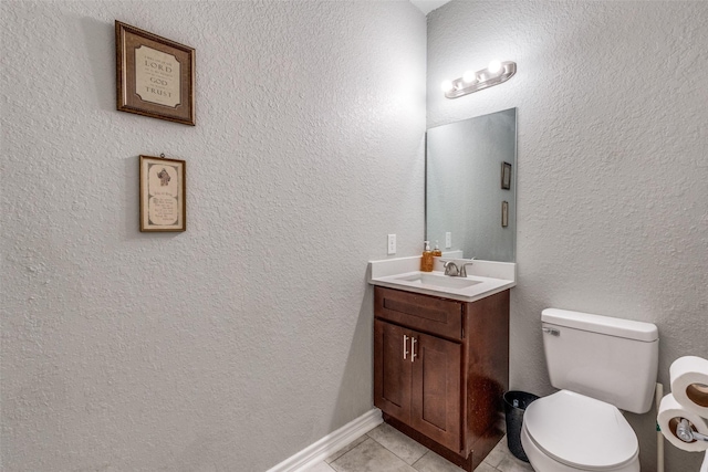 bathroom with toilet, vanity, and tile patterned floors