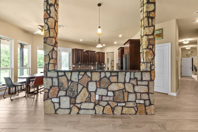 kitchen with pendant lighting, high quality fridge, decorative backsplash, kitchen peninsula, and ceiling fan