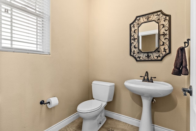 bathroom with toilet and tile patterned flooring