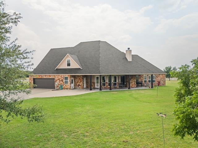 back of property with a lawn and a garage