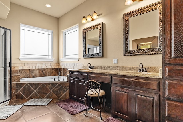 bathroom featuring vanity, tile patterned flooring, and a relaxing tiled tub