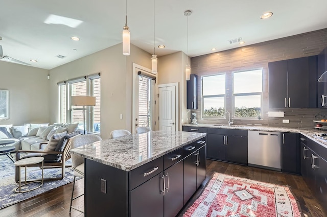 kitchen featuring a kitchen bar, a center island, dishwasher, pendant lighting, and sink