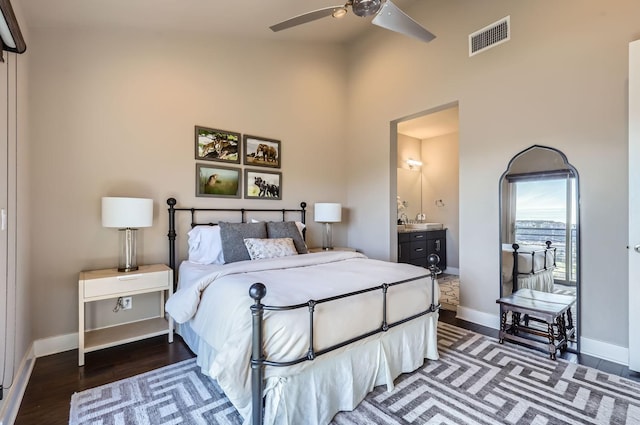 bedroom featuring ceiling fan, ensuite bathroom, and dark hardwood / wood-style flooring