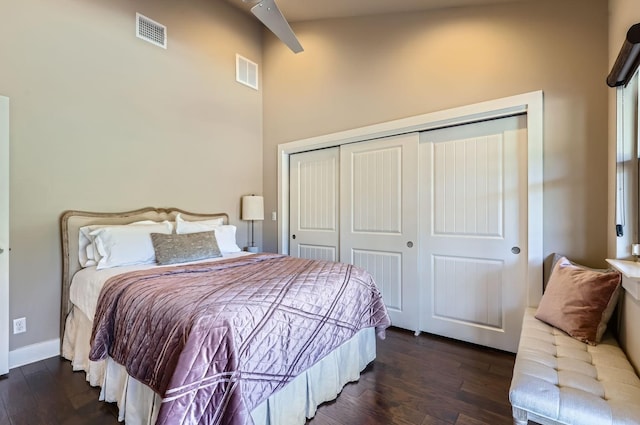 bedroom with ceiling fan, dark wood-type flooring, and a closet