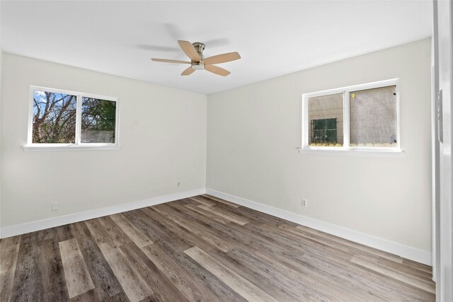 empty room with ceiling fan and hardwood / wood-style flooring