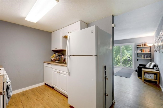 710 E Dean Keeton St Unit 210, Austin, TX 78705 - kitchen with white appliances, white cabinetry, light wood-style flooring, and light countertops