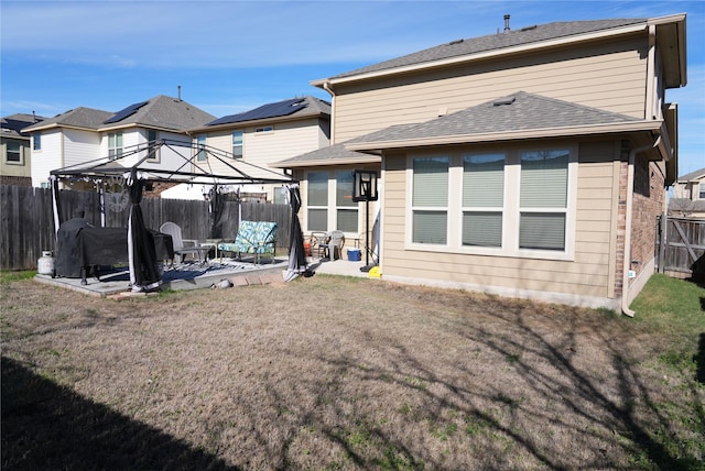 rear view of house with a lawn, a gazebo, and a patio area