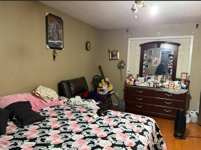 bedroom with a textured ceiling and hardwood / wood-style flooring