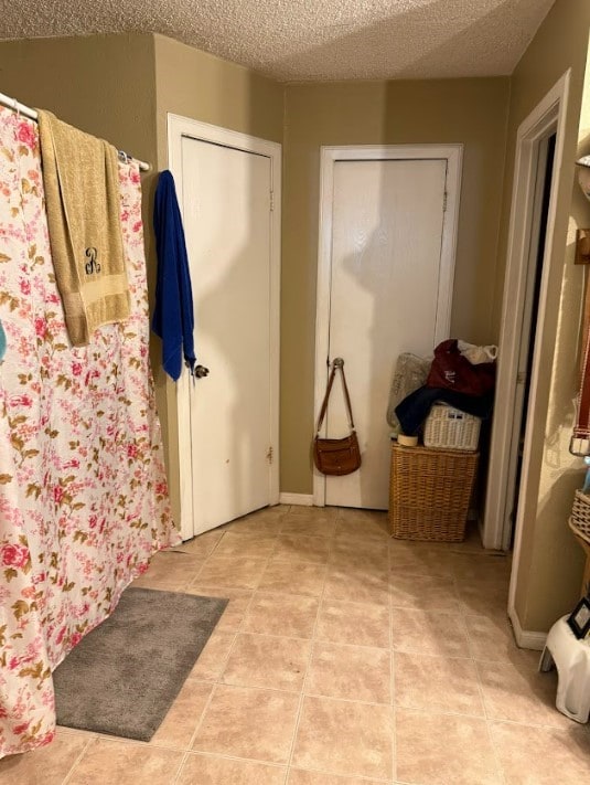 bathroom featuring a textured ceiling and tile patterned floors