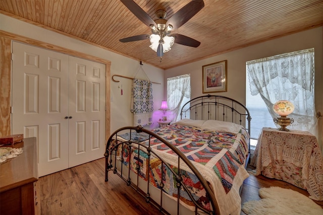 bedroom featuring hardwood / wood-style floors, wooden ceiling, ceiling fan, a closet, and ornamental molding