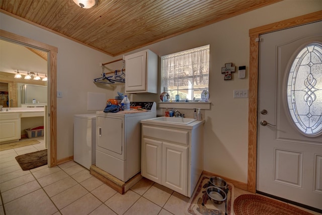 clothes washing area featuring sink, wood ceiling, separate washer and dryer, light tile patterned floors, and cabinets