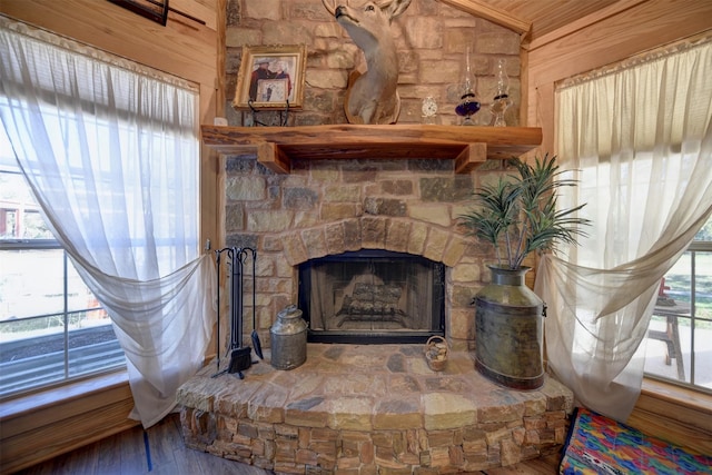 details featuring wood-type flooring, a stone fireplace, and wooden walls