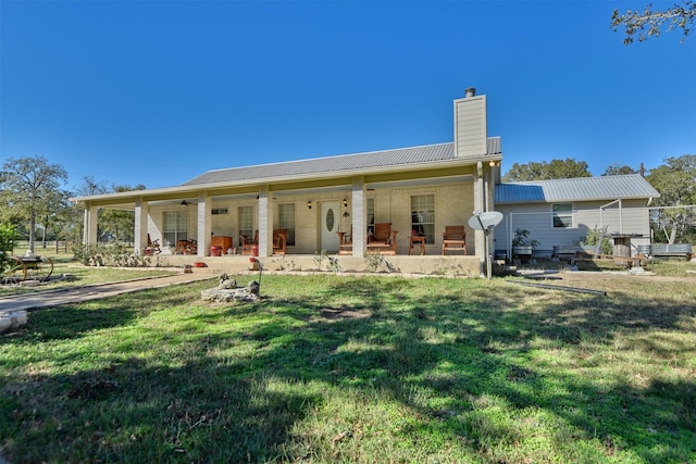 back of property featuring ceiling fan, a yard, and covered porch