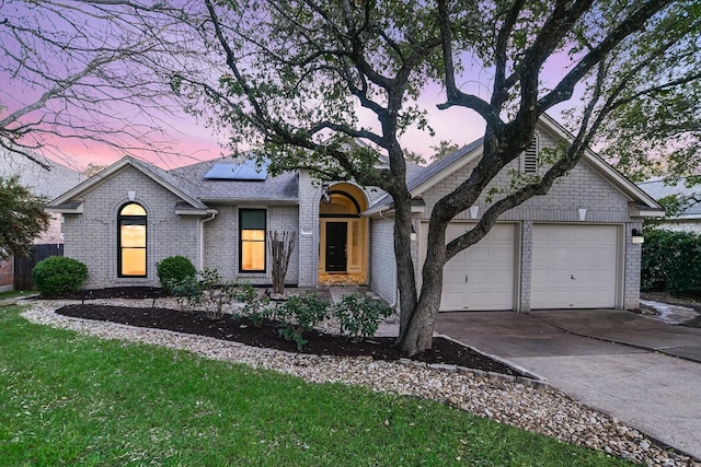 view of front of property featuring solar panels and a garage