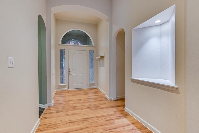 foyer entrance featuring ornamental molding and light hardwood / wood-style flooring