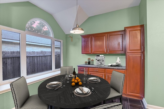 6817 Beatty Dr, Austin, TX 78749 - kitchen with vaulted ceiling, hanging light fixtures, dark countertops, and brown cabinets